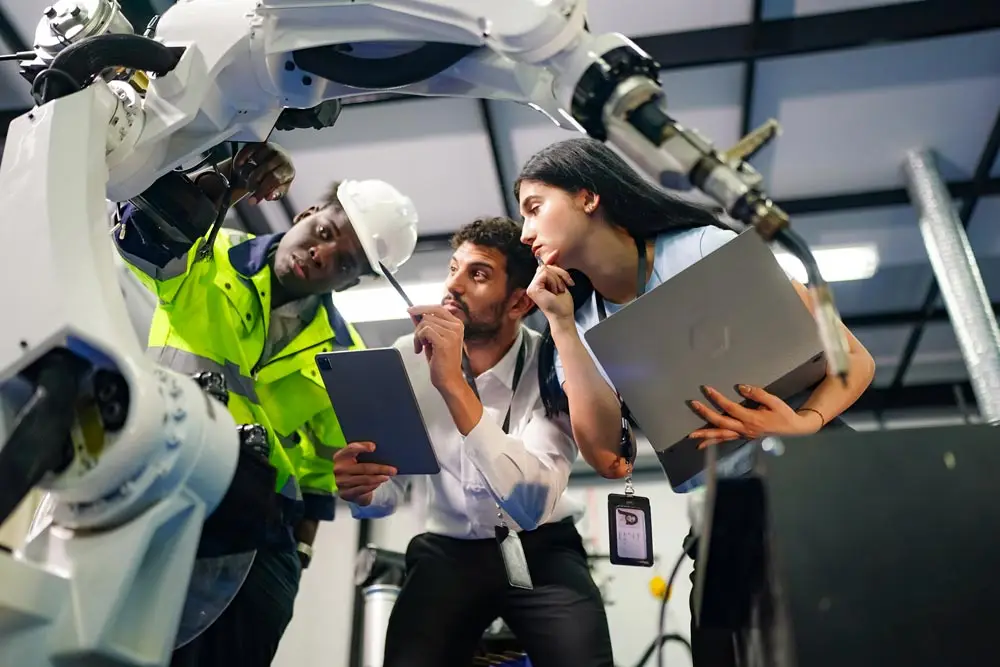 workers inspecting a robotic arm