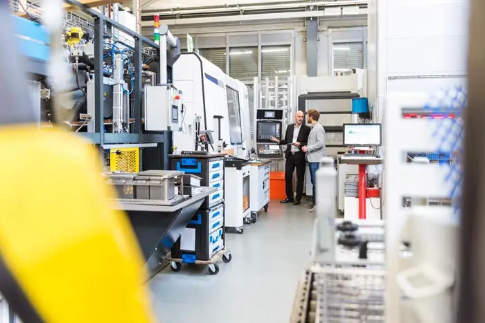 two workers using a tablet in a factory
